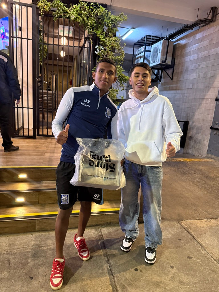 Dos personas sosteniendo una bolsa de RUKI STORE.
