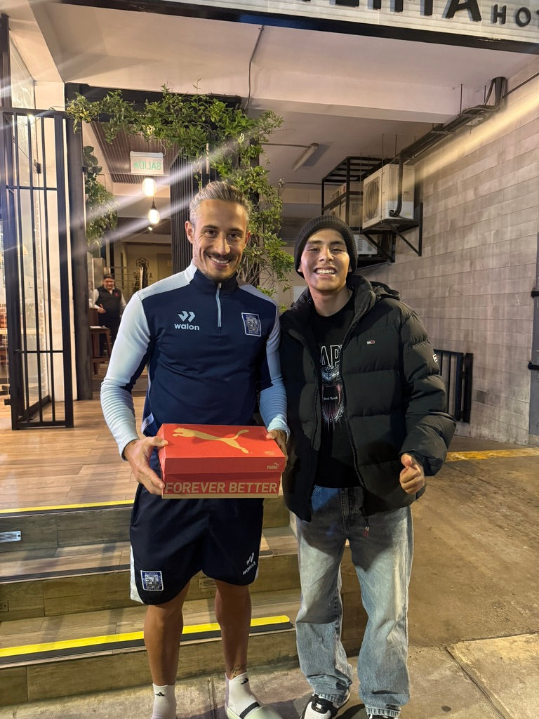 Dos personas mostrando una caja de calzado.