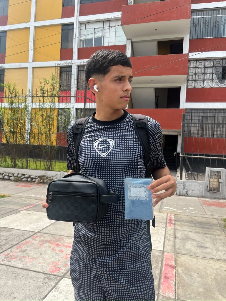 Una persona sosteniendo un neceser de patrón cuadriculado.