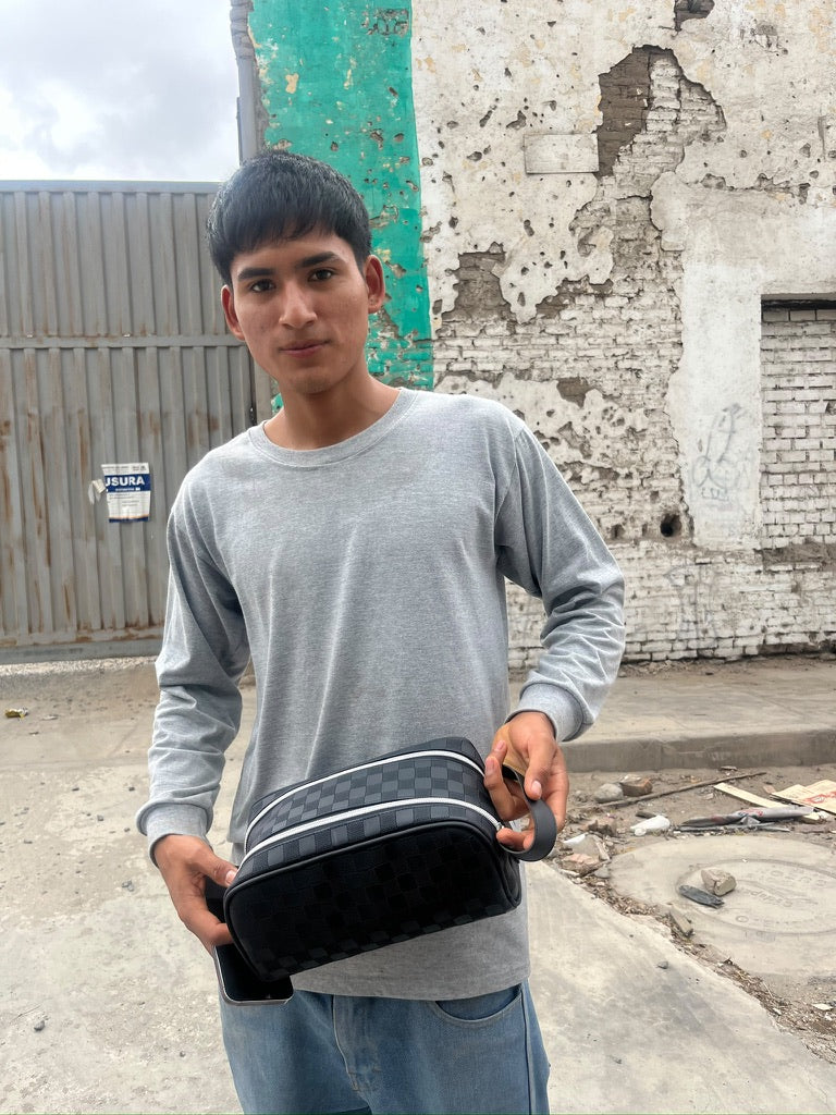 Una persona mostrando un neceser de patrón cuadriculado.