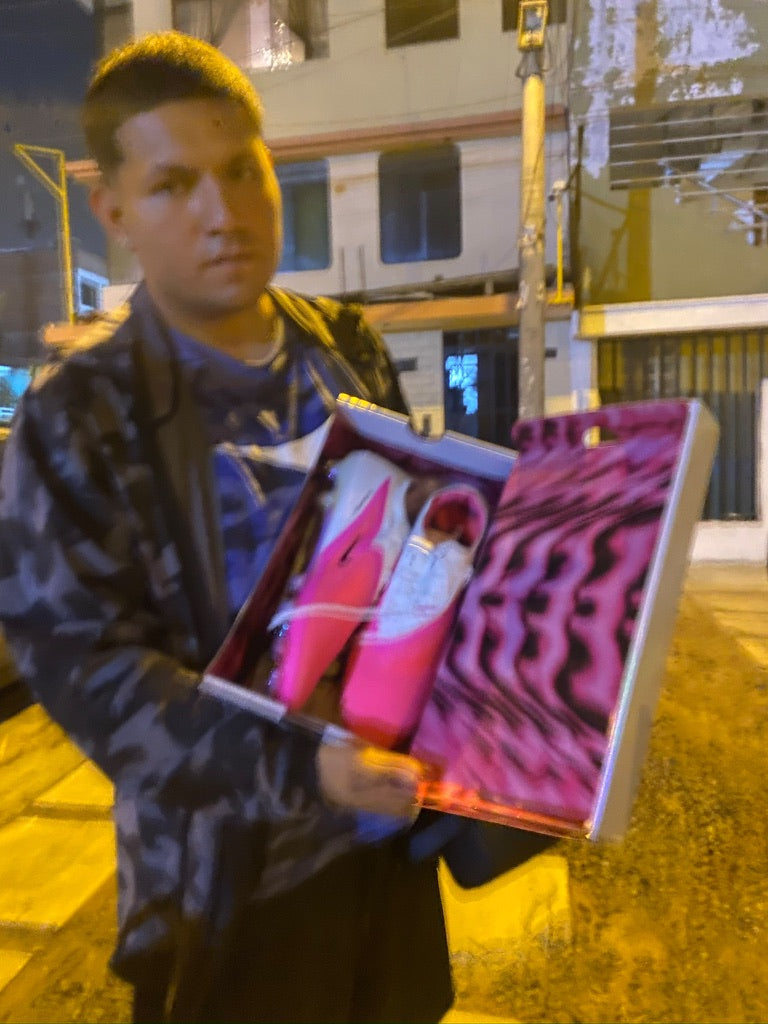 Una persona mostrando chimpunes rosados en una caja.