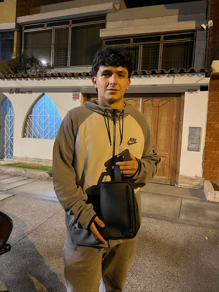 Una persona sosteniendo un neceser negro.